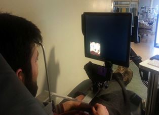 A patient watches a video while eye movements are tracked by a camera