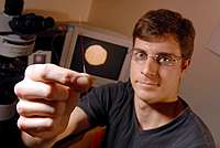 Postdoctoral fellow Jean-Francois Masson holds a microelectrode modified with a biosensing layer capable of measuring adenosine triphosphate (ATP) release on cell surfaces.