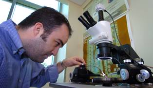 Pedro Irazoqui uses a "radio frequency probe station" to test tiny circuits in the miniature device designed to be implanted in the brain to predict epileptic seizures.